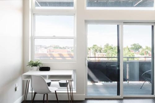 a white room with a desk and chairs and a balcony at New Spacious Modern Loft - Center of LoHi in Denver