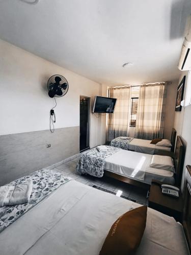 a bedroom with two beds and a flat screen tv at ISIS HOTEl in Tumbes