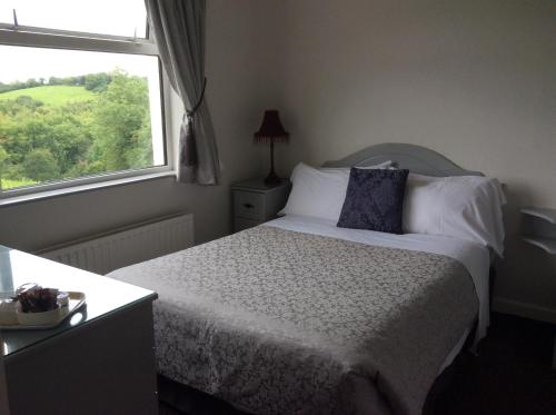 um quarto com uma cama grande e uma janela em The Meadows Bed and Breakfast em Monaghan