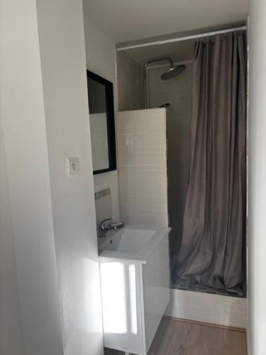 a white bathroom with a sink and a mirror at La Cigalière 2 charmant T2 avec terrasse dans villa in Solliès-Ville