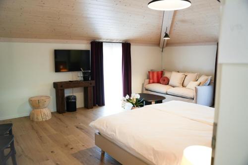a bedroom with a bed and a couch at Locanda del Persico in Morbio Inferiore