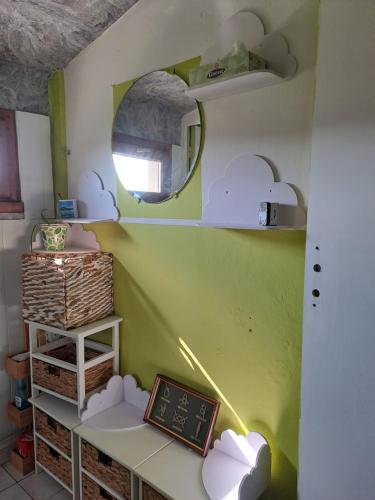 a room with a green wall with a table and a mirror at Halte à Ecluse d'Hôte in Calonges