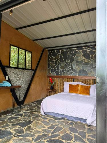 a bedroom with a bed in a stone wall at Eco Meeting in Cali