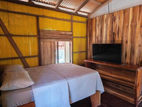a bedroom with a bed and a flat screen tv at Parque Indigo Nature Lodge, Rincón de la Vieja in Liberia