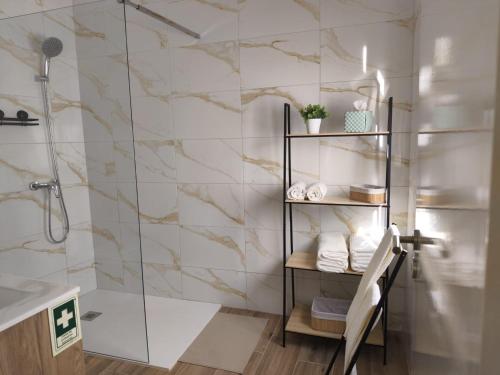 a bathroom with a shower with marble tiles at Flor de Charme in Campo Maior
