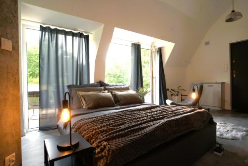 a bedroom with a large bed and a large window at Bunkier House in Niedźwiada