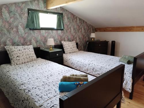 a bedroom with two twin beds and a window at Le Cigalou - Drôme Provencale in Sainte-Jalle