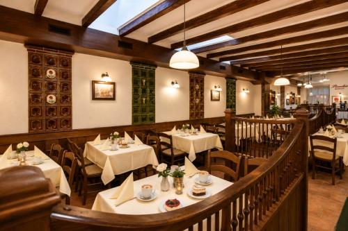 a restaurant with tables and chairs in a room at Hotel Piroska in Bük