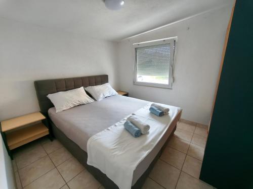 a bedroom with a bed with two bags on it at Apartments Šešo A in Pag
