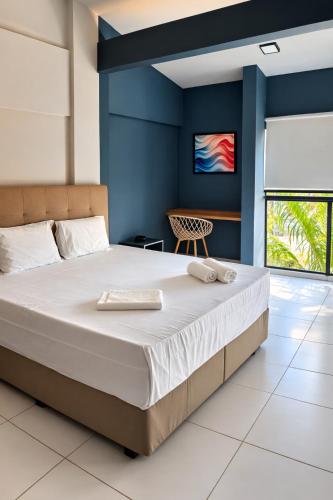 a bedroom with a large bed with blue walls at City Studios Apartamentos Novos em Natal in Natal