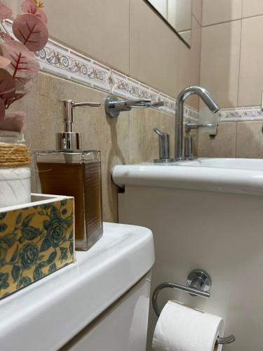a bathroom with a sink and a toilet with a dispenser at Complejo Punto Medio in Santa Rosa
