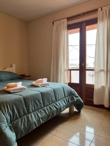 a bedroom with a bed with two towels on it at Complejo Punto Medio in Santa Rosa
