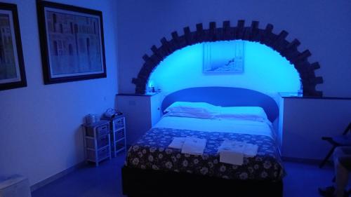 a bedroom with a bed with a blue light at enrica barrani room in Vernazza