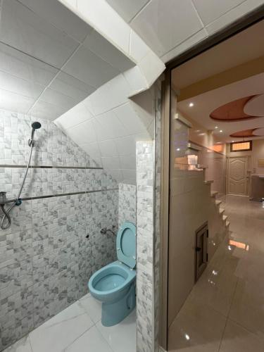 a bathroom with a blue toilet in a room at Quiet Aourire Hideway in Aourir