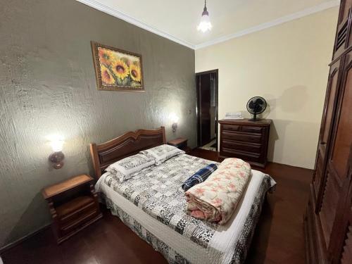 a bedroom with a bed and a dresser at Casa aconchegante para família- 3,5 km do centro histórico in Petrópolis
