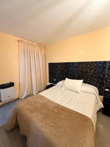 a bedroom with a large bed with a black wall at Loft Don Bosco in San Luis