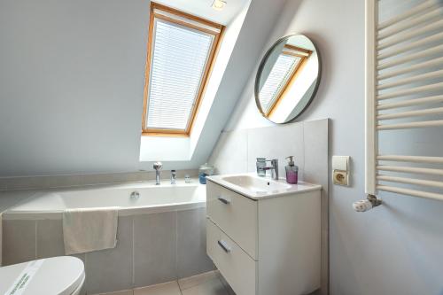 a bathroom with a sink and a tub and a mirror at Apartamenty Centrum - Moonlight in Opole