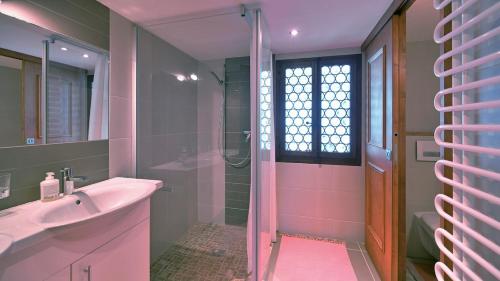 a pink bathroom with a sink and a shower at Cozy Le Lézard chalet with mountain view fireplace in Les Diablerets