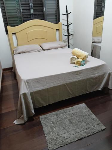 a bedroom with a large bed with a wooden headboard at Aero Hospedagem Londrina in Londrina