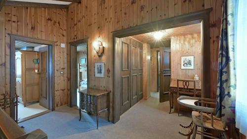 a room with wooden walls and a bathroom with a sink at Cozy Le Lézard chalet with mountain view fireplace in Les Diablerets