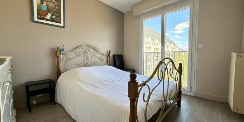 a bedroom with a white bed and a large window at Le Balzac - 2 Chambres - Balcon in Tours