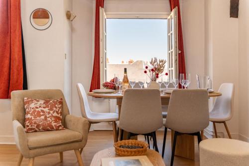 a dining room with a table and chairs and a window at Duplex de charme dans un Cloître historique Parking privé in Rouen