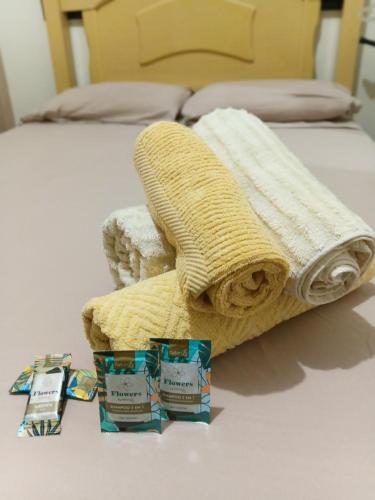 a bed with two towels and two candles on it at Aero Hospedagem Londrina in Londrina