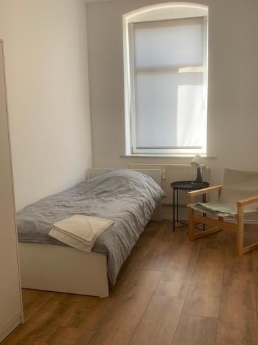 a bedroom with a bed and a window and a table at Arnold Apartments in Glauchau