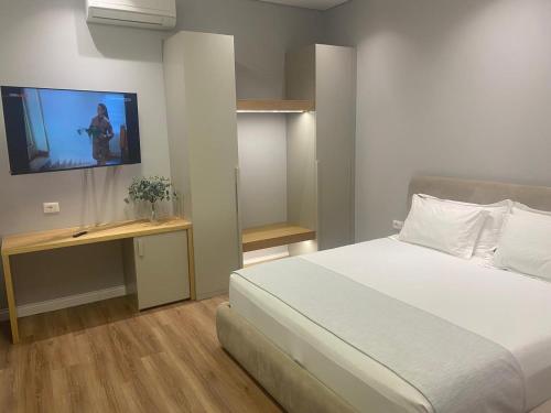 a bedroom with a bed and a tv on the wall at Arvi Boutique Hotel in Lukovë