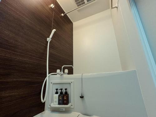 a bathroom with a toilet with bottles in it at NUPRIME morishita in Tokyo