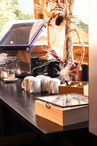 a counter with cups and a coffee maker on it at Le Sire de Joux in Montbenoît