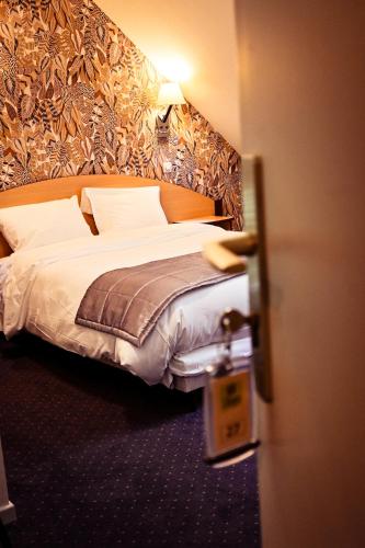 a bed in a hotel room with at Le Sire de Joux in Montbenoît