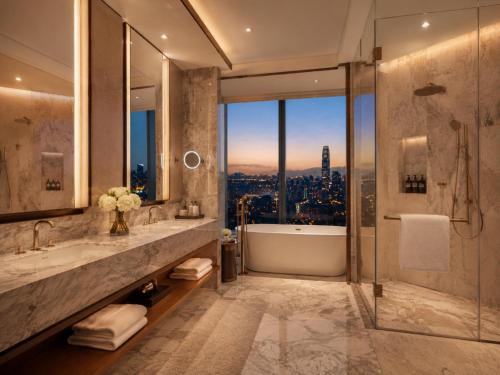 a bathroom with a tub and a shower with a view at Hotel Platinum Square in New Delhi