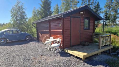 a small cabin with a car parked next to it at Paradise cottage w sea view in Brännöviken 5, Lögdeå in Lögdeå
