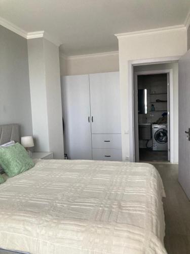 a white bedroom with a bed and a kitchen at AL Mаre in Batumi