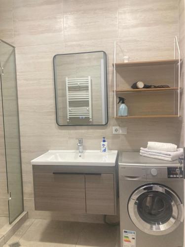 a bathroom with a sink and a washing machine at AL Mаre in Batumi