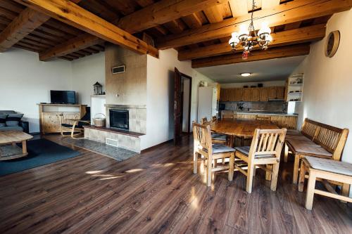 a kitchen and dining room with a wooden table and chairs at Chata u Mikiho Krahule in Krahule