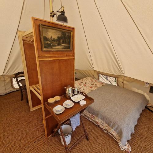 a room with a table and a bed in a tent at Eco glamping tent 'Basilikus' in Laakdal