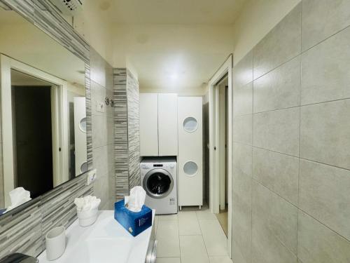 ein Badezimmer mit Waschmaschine und Spiegel in der Unterkunft FaraHome in Acitrezza