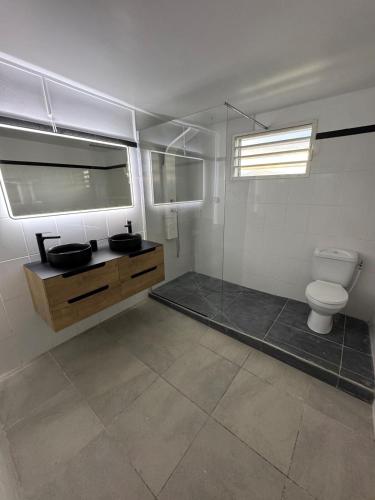 a bathroom with two sinks and a toilet at Spacieux logement in Lamentin