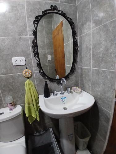 a bathroom with a sink and a mirror and a toilet at Sudecada in Toay