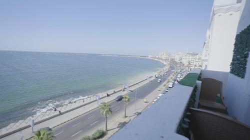 a view of a beach and the ocean from a balcony at New Welcome House Hotel in Alexandria