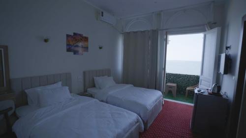 a hotel room with two beds and a window at New Welcome House Hotel in Alexandria