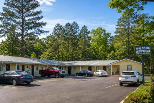 a building with cars parked in a parking lot at Riviera Motel Elba Near Enterprise US 84 in Elba