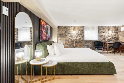 a bedroom with a bed and a stone wall at Manoir de la Tour - Par Aneyro in Quebec City