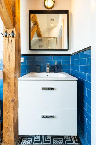 a bathroom with a white sink and a mirror at Apartamenty Centrum - Sunshine in Opole