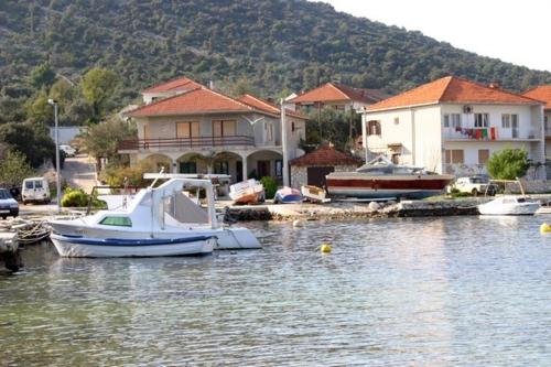 a boat is docked in a marina with houses at Apartments Ivan Orlic in Vinišće