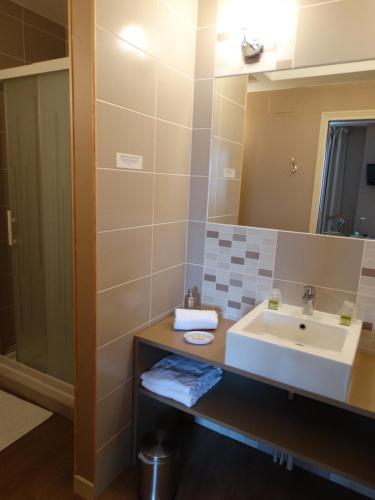 a bathroom with a sink and a mirror at Logis Auberge du Valburgeois in Sainte-Gauburge-Sainte-Colombe