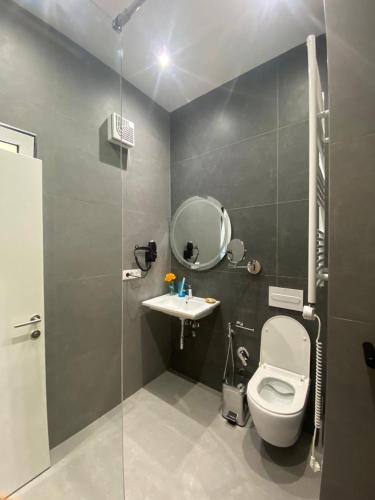 a bathroom with a toilet and a sink and a mirror at Arvi Boutique Hotel in Lukovë