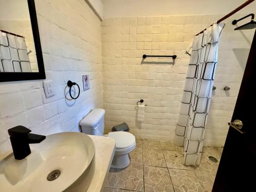 a bathroom with a sink and a toilet at Paseo Kuka by ÓOL Hotels in Holbox Island